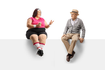 Young overweight woman holding a healthy green smoothie and talking to an elderly man