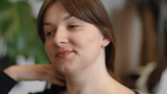 Headshot portrait of happy young woman smiling touching new haircut in slow motion. Close-up satisfied Caucasian client in beauty salon with new hairstyle