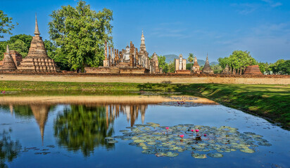 Naklejka premium Wat Mahathat Buddhist temple in Sukhothai historical park. UNESCO and World Heritage Site. Culture and vacation concept.