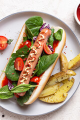 Fast food hot dog with sausage and tomatoes and fried potatoes