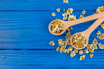 Dry chamomile flowers on a wooden table. Soothing chamomile tea. Herbal drink. flat layout. Space for text.Copy space.Medical prevention and immune concept. Folk alternative medicine.