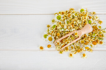 Dry chamomile flowers on a wooden table. Soothing chamomile tea. Herbal drink. flat layout. Space for text.Copy space.Medical prevention and immune concept. Folk alternative medicine.