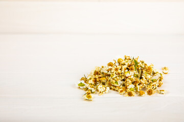 Dry chamomile flowers on a wooden table. Soothing chamomile tea. Herbal drink. flat layout. Space for text.Copy space.Medical prevention and immune concept. Folk alternative medicine.
