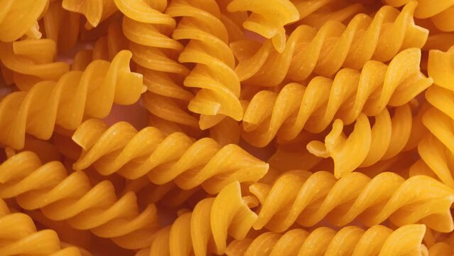 dry pasta fusilli , rotation in circle. dry spirals Turning. selective focus. 
