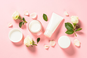Obraz na płótnie Canvas Natural cosmetics with rose oil, Skin care product - cream, lotion, soap on pink background with rose flowers. Flat lay image with copy space.