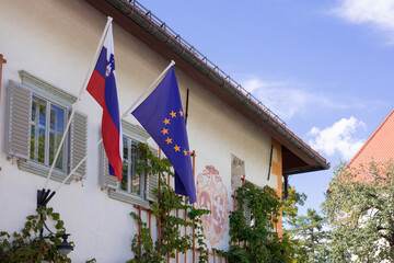 flags of both Slovenia and European Union on the on the wall in sunny day