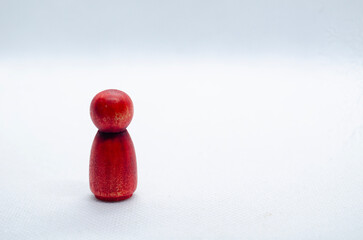 Close up of red wooden figure on white background with customizable space for text. Copy space.