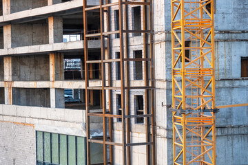 Construction of high-rise building. Metal frame near house. Engineering structure at construction site. Construction of panel skyscrapers. Build residential property. Building industry background