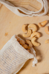 Cashew nut on cotton bag. Beige composition.