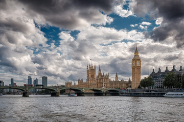 Big Ben and the Houses of Parliament with buses crossing the Westminster bridge passing over the...