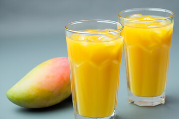 A refreshing glass of cold mango juice with droplets of condensation, perfect for quenching your...