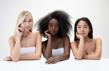 Portrait of beautiful young multiracial women, caucasian asian and african against white...