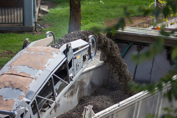Hot mix asphalt poured down into tipper truck workbody. Contemporary technology 