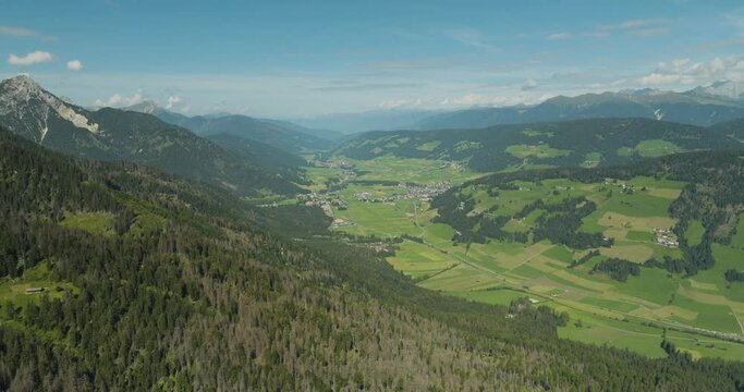 Aerial view of Dobbiaco town as seen from Croda dei Baranci (Birkenkofel) mountain peak on the Dolomites range, Trentino, South Tyrol, Italy.