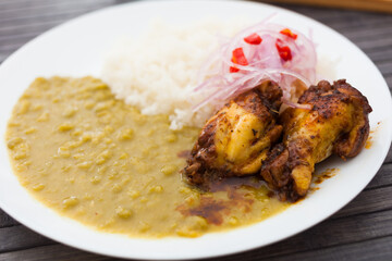 Traditional Peruvian dish. chicken wings with pea puree, rice and pickled onions