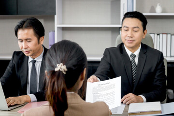Human resources officer receiving CV resume from candidate woman who looking new job, two businessman managers interviewing new employee, people have discussion meeting, career job interview concept