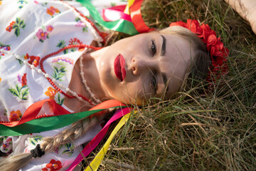Portrait of a girl on the grass in the national Ukrainian costume.