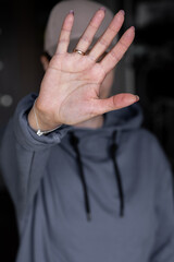 Close-up focus on a woman showing a stop gesture to the camera, blurred background, a strong young...