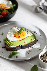 Breakfast wirh toast with avocado and eggs on a plate
