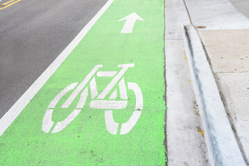 Empty green coloured bicycle lane runnig along a street in a downtown district
