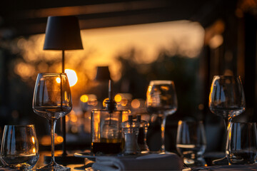 Table à la terrasse d'un restaurant au coucher du soleil - obrazy, fototapety, plakaty