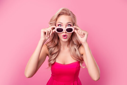 Portrait of impressed nice person arms touch sunglass pouted lips cant believe isolated on pink color background