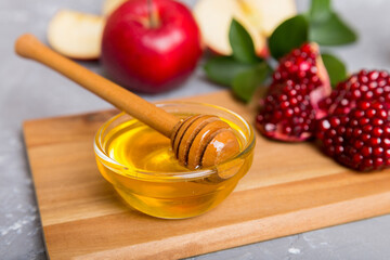 Rosh hashanah, jewish holiday, concept: honey, apple and pomegranate with cutting board, close up