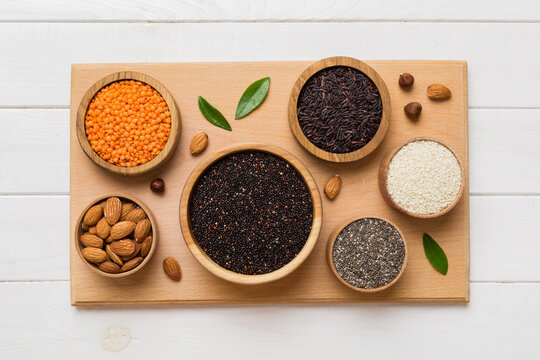 Various superfoods in smal bowl on colored background. Superfood as rice, chia, quinoa, lentils, nuts, sesame seeds, almonds. top view