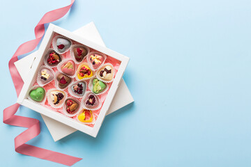 Holiday composition: sweet candy, with gift boxes with bow and chocolate hearts, photo template,...