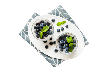 Healthy breakfast or morning with chia seeds vanilla pudding and blueberry berries on table background, vegetarian food, diet and health concept. Chia pudding with coconut milk and blueberry