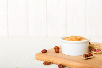 Bowl of peanut butter and peanuts on table background. top view with copy space. Creamy peanut pasta in small bowl