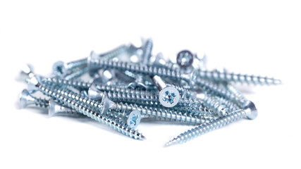 Chrome screw on white background. Tapping screws from steel close-up