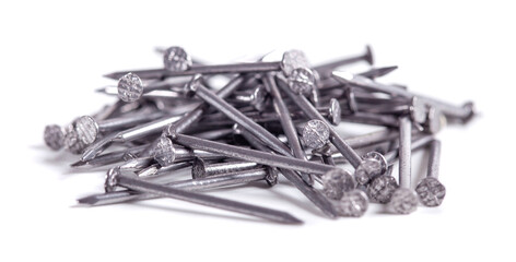 Pile of small grey metal nails isolated on white background. Close-up