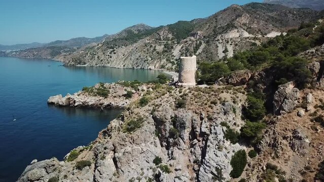 Aerial view of Torre de la Caleta, a ruin tower on the cliff along the coastline, La Herradura, Granada, Spain.