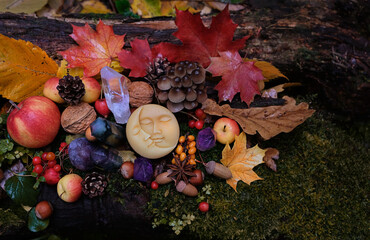 Moon amulet, fruits, berries, fall leaves, crystal gemstones in forest, natural background. Wiccan...
