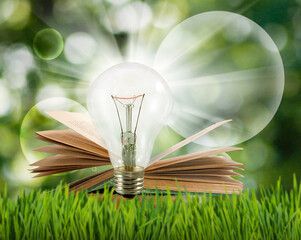  light bulb over an open book is a symbol of the concept of knowledge, learning and inspiration....
