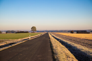 Fototapeta na wymiar Road in the morning in the countryside with fog and ice