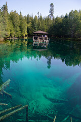 Turquoise clear waters at Kitch-iti-kipi spring in Michigan's Upper Peninsula, visitor viewing raft