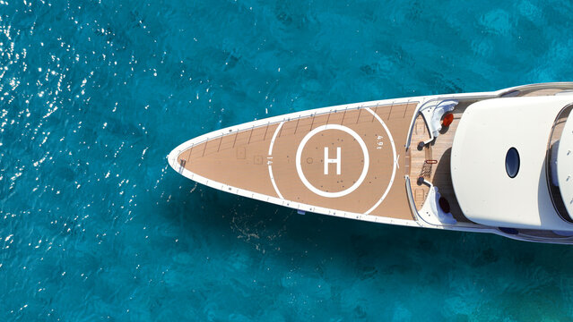 Aerial drone top down photo of luxury yacht with wooden deck and helipad anchored in paradise exotic turquoise island bay