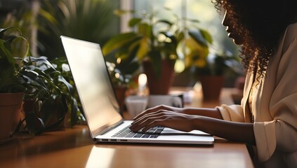 Young African American businesswoman working on laptop in office, closeup