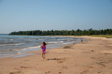 Girl in pink running on beach, Lake Michigan