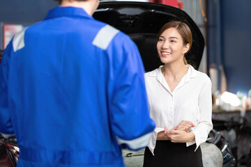 woman customer meeting mechanic and talking about how to fix a car in automobile repair shop