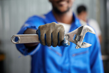 closeup worker or technician hands holding wrench and fist bump pose in the factory