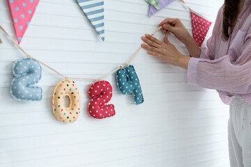 Woman holds a rope with the number 2024 on it and, number 2024 made from beautifully printed fabric