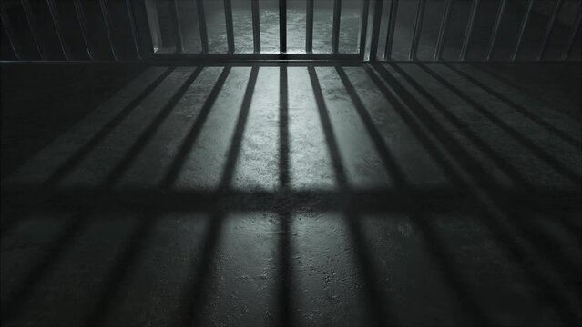 A slow camera pan closeup showing a dimly lit concrete floor of a prison cell and the cast shadows of the jail cell door slamming shut
