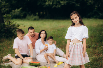 a girl on a picnic with her parents and two brothers