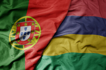 big waving national colorful flag of portugal and national flag of mauritius .