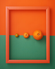 Orange, clementine, cherry tomato in frame on orange and green