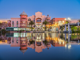 Fototapeta premium Canal Walk building lit up at night with lights reflection on the canal, Century City, Cape Town, South Africa