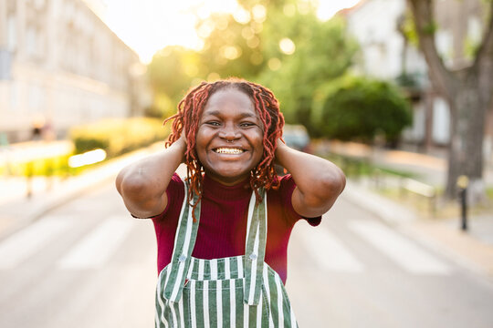 Cheerful non-binary person standing on the street in the city
